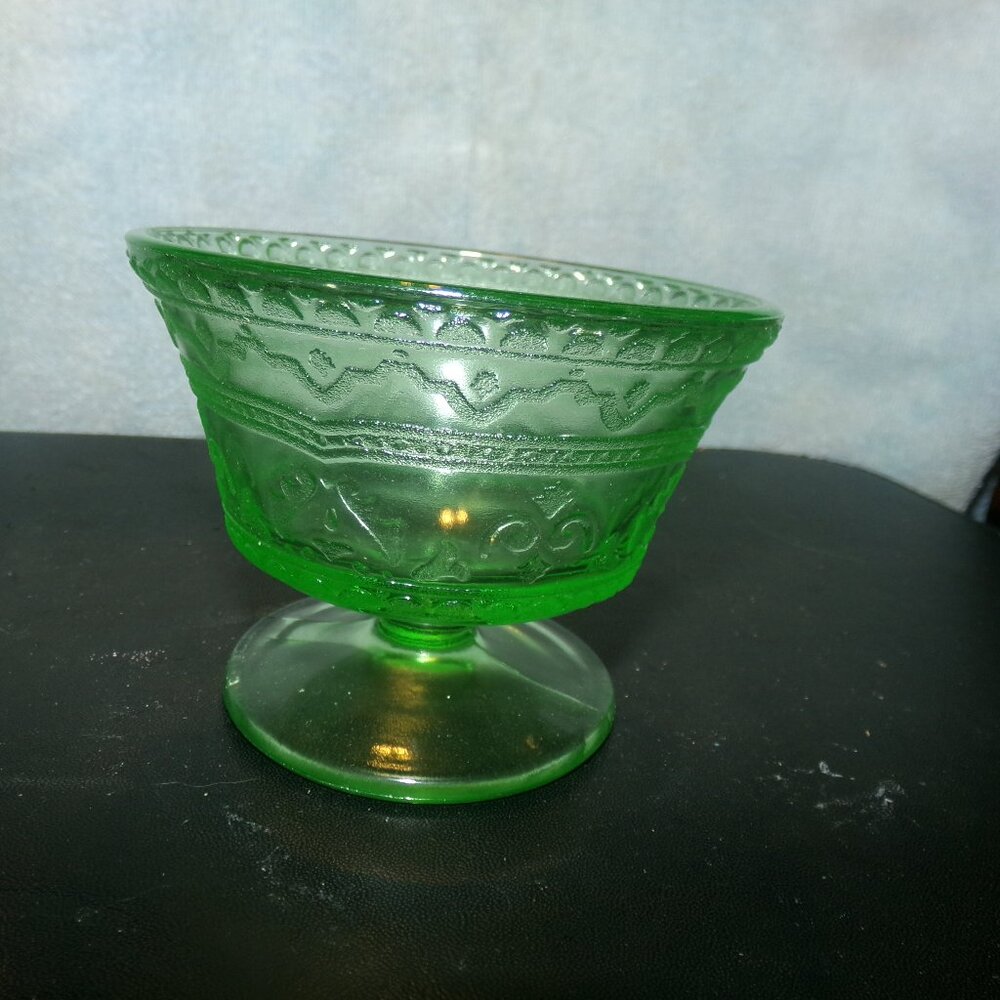 green depression glass sherbet dish glows.